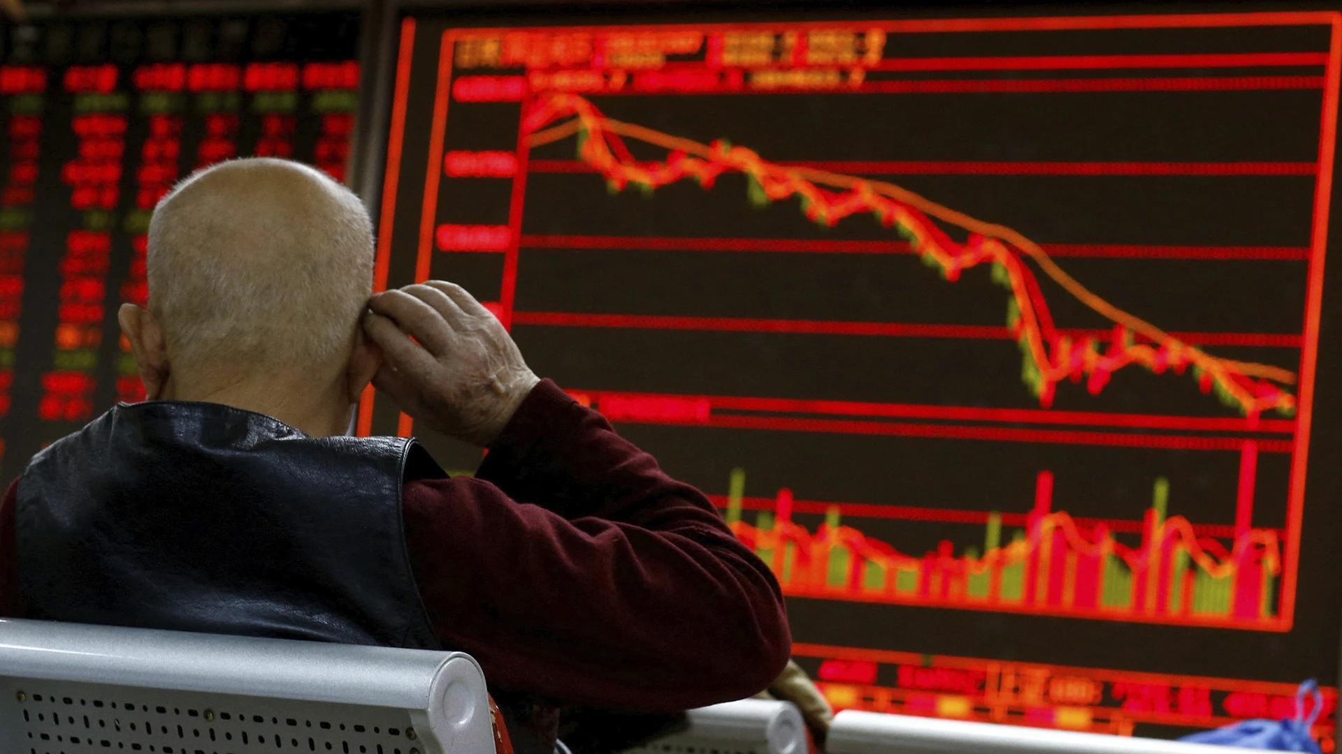 Инвестор изучает табло с биржевой информацией в брокерской конторе в Пекине / Фото: Reuters/Thomas Peter